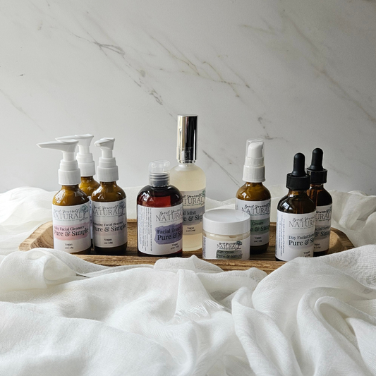 Collection of natural skincare products on a wooden tray with a white marble background