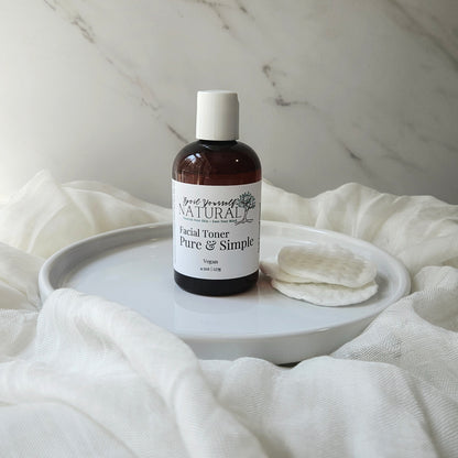 A bottle of gentle facial toner and a cotton pad placed on a white plate, with the product label visible.
