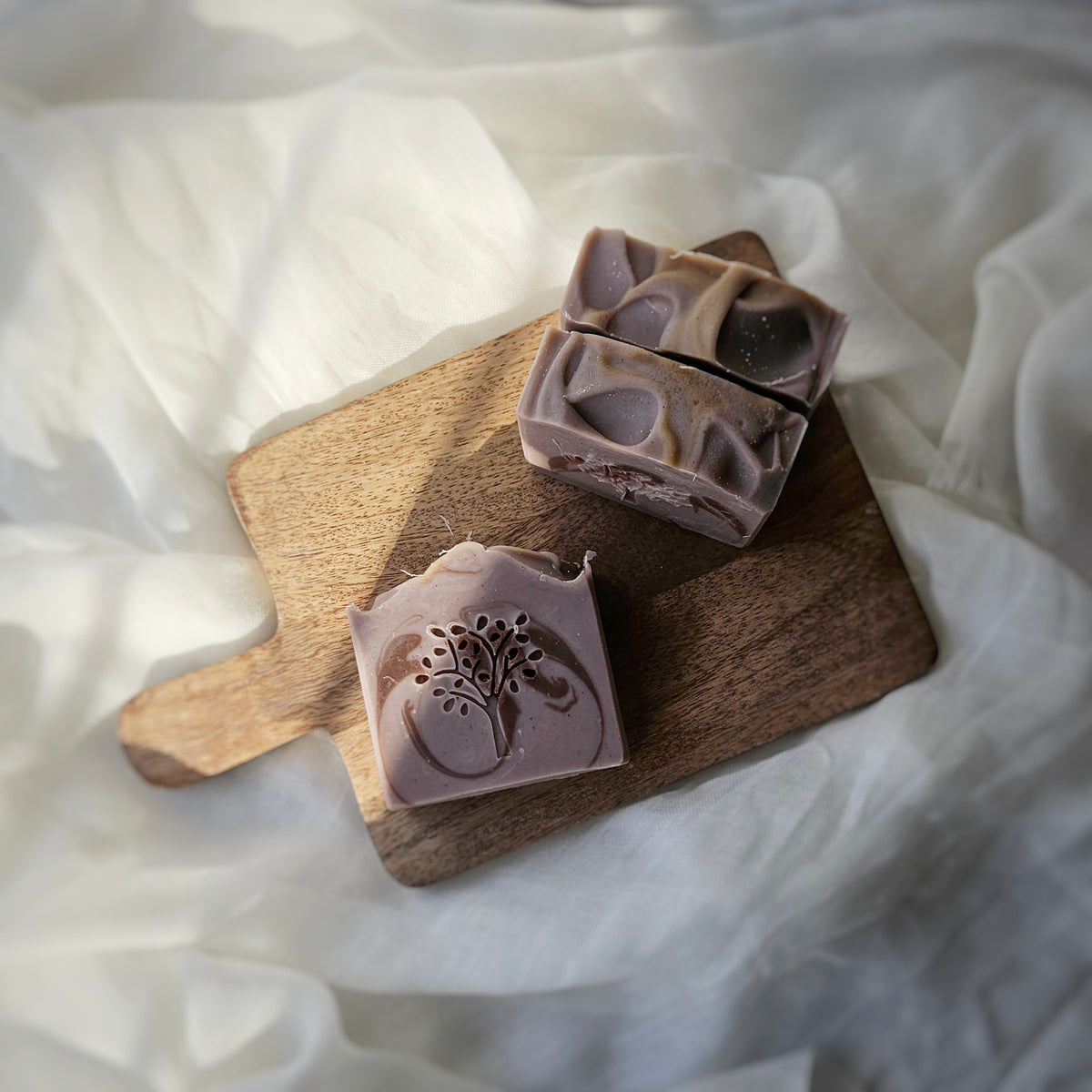 three bars of soaps sitting on a wooden dish