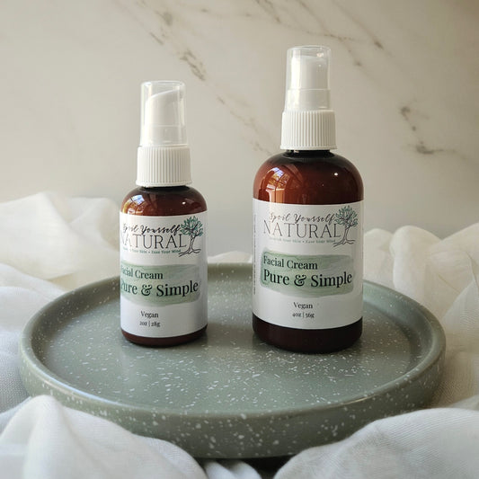 Two bottles of 'Pure & Simple' facial cream on a gray tray with a neutral background.
