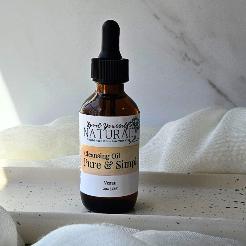 a bottle of cleansing oil in a white plate with fabric underneath
