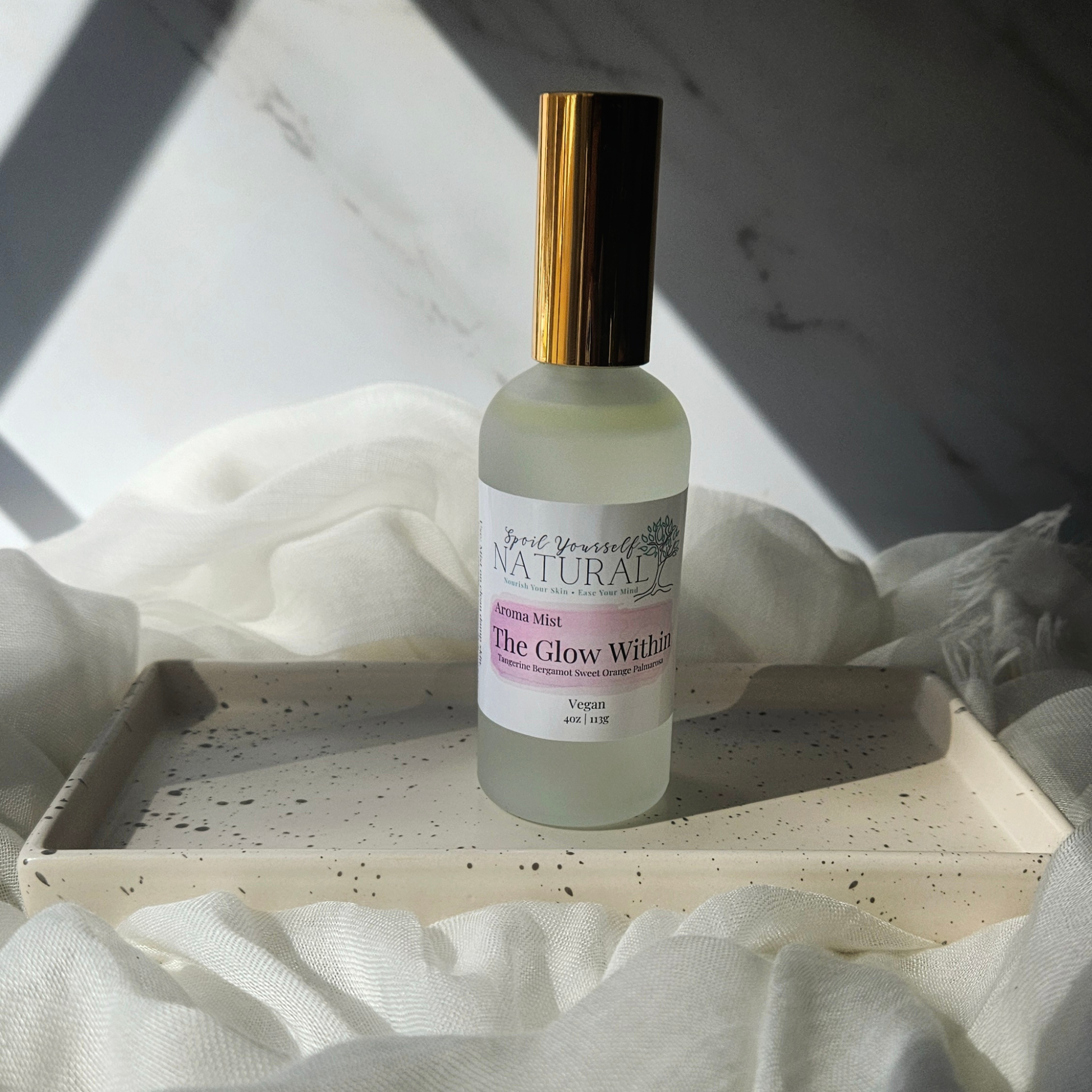 Skincare bottle labeled 'Naturally' on a white surface with soft lighting