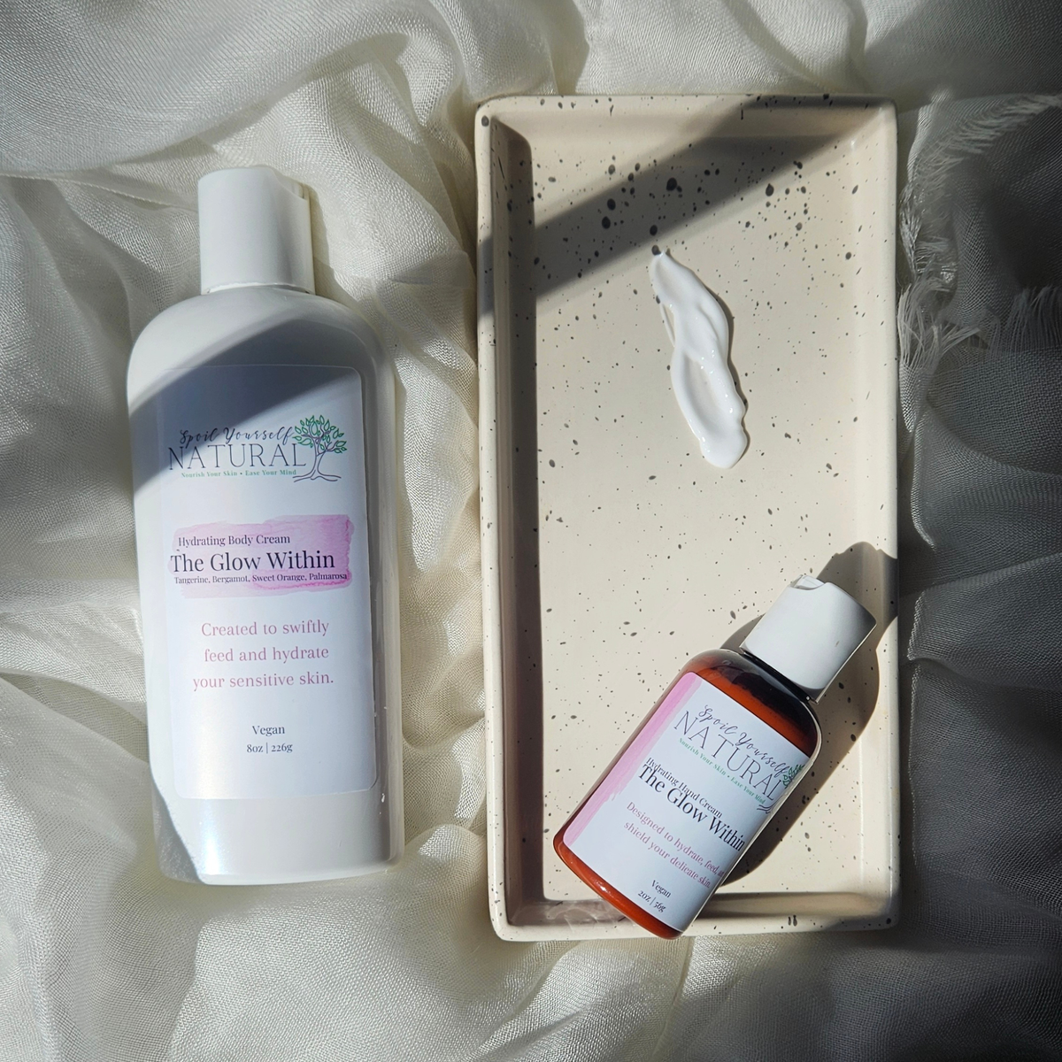 Two skincare products on a textured surface with a soft background