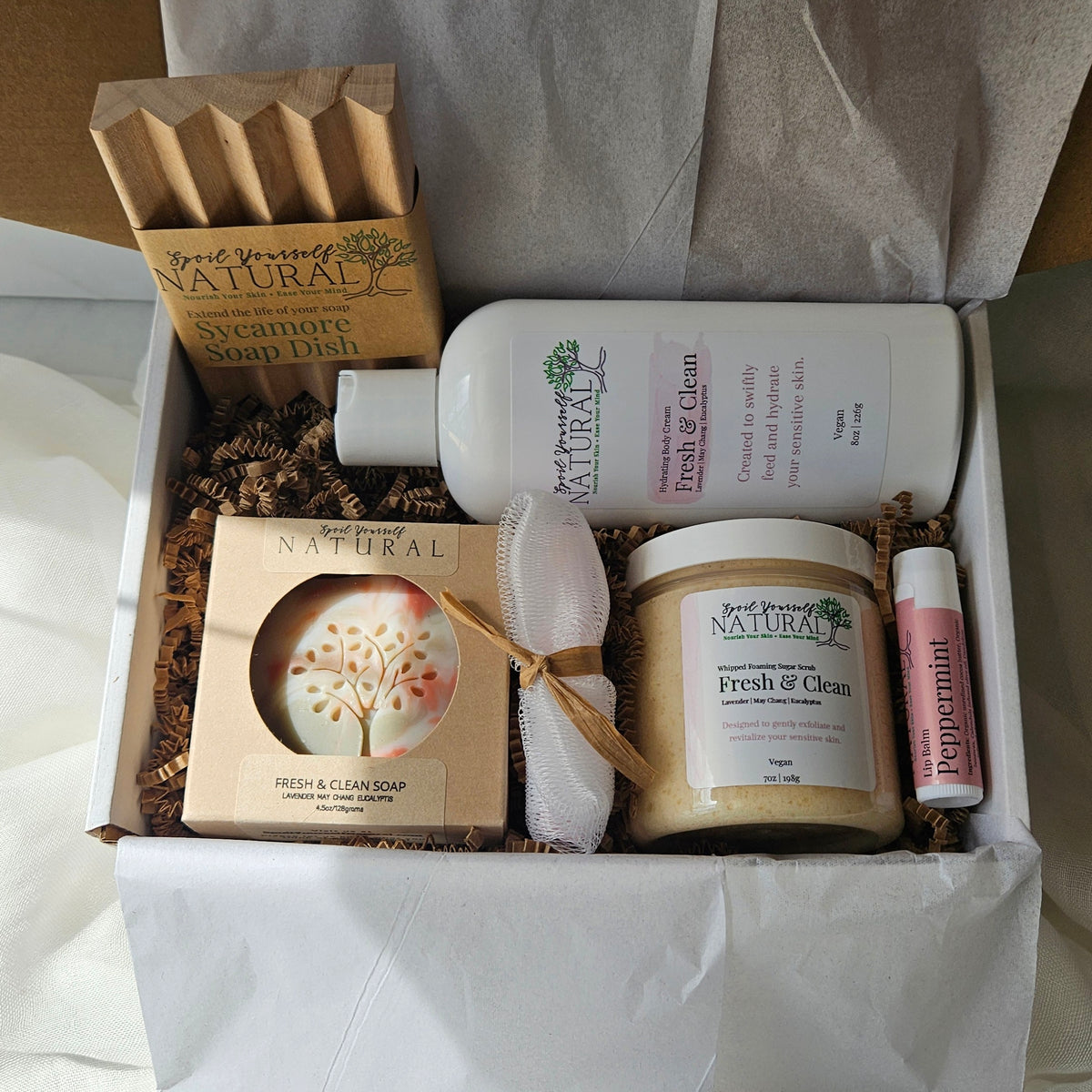 Assorted natural products including soap, scrub, and lotion in a box.