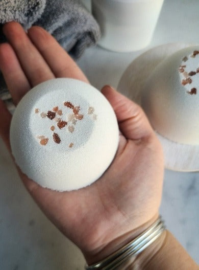 bath bomb sitting in a persons hand showing size